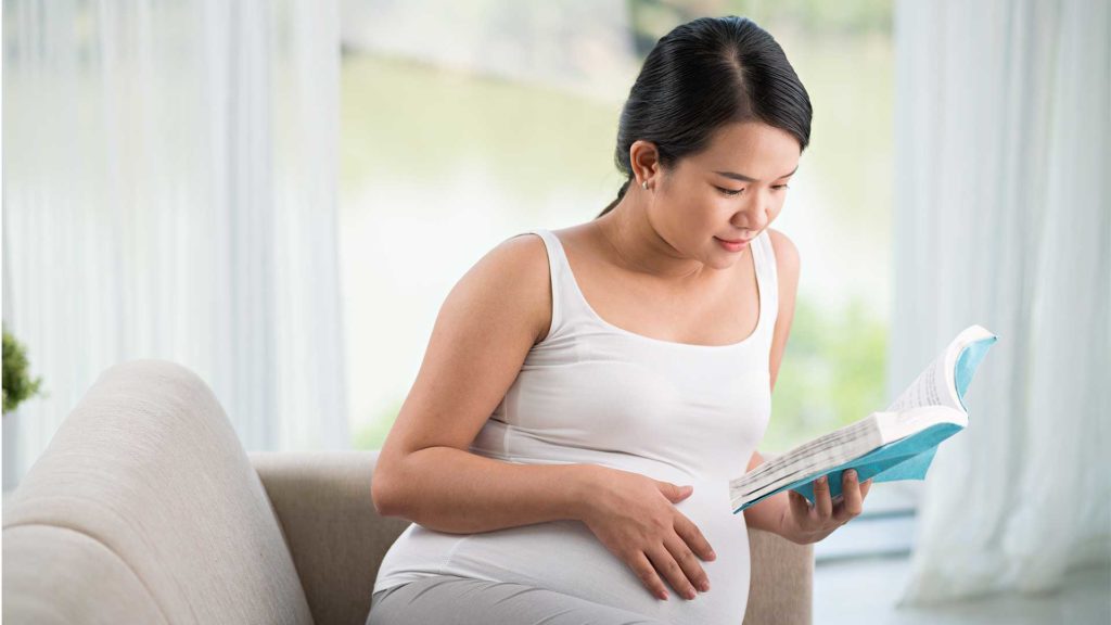 woman reading book to prepare for childbirth
